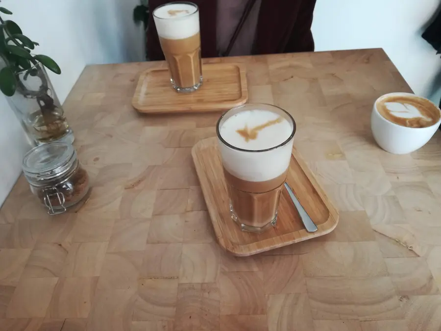 Latte Macchiato im Glas auf einem Holztablett